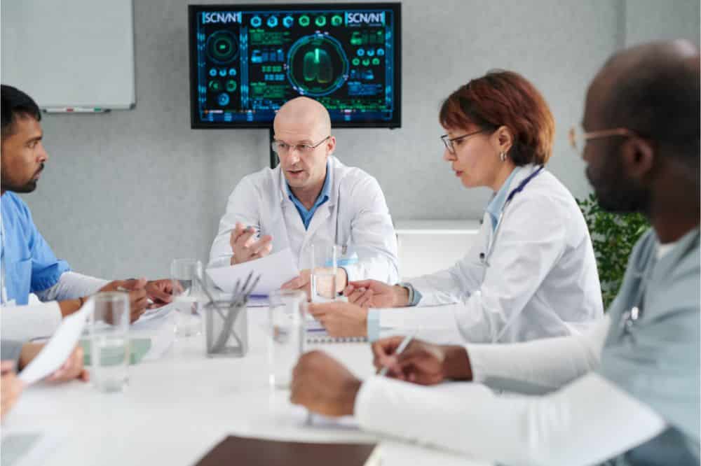Group of medical team discussing the ways of treatment at table during meeting
