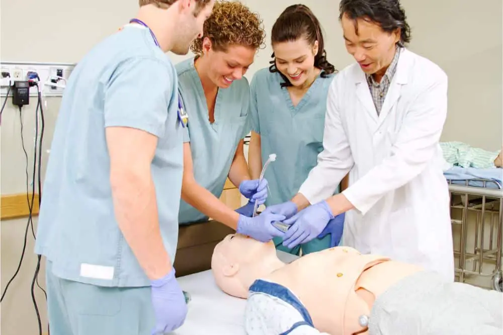 Medical staff practicing intubating mannequin