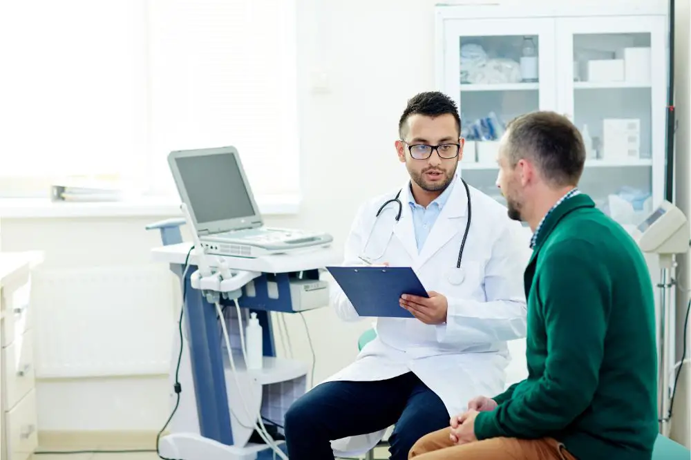 Middle-aged bearded patient having consultation with highly professional physician at modern office
