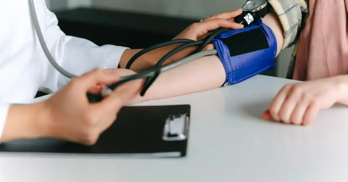 The doctor is using a blood pressure machine to check the patient's blood pressure